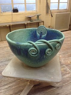 a blue bowl sitting on top of a wooden table next to a pair of scissors