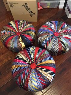 three colorful round poufles sitting on top of a wooden floor next to a box