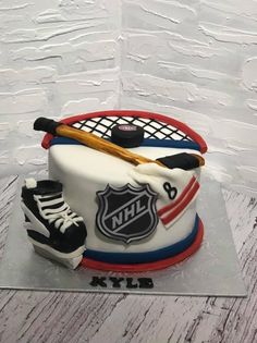 a cake with hockey gear on it and a bat in the middle, sitting on top of a table