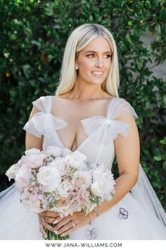 a woman in a wedding dress holding a bouquet