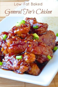 a white plate topped with meat covered in bbq sauce and green onions next to rice