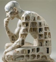 a sculpture of a man sitting on top of a table