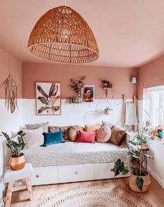 a living room filled with lots of furniture and plants on top of a rug next to a window