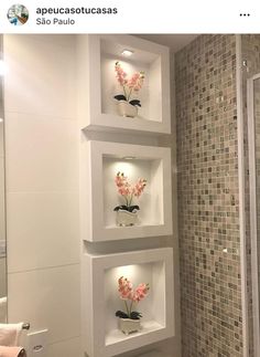 the bathroom has three shelves with flowers on them