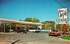 an old photo of cars parked in front of a store