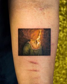 a tattoo with a dog's head on the left side of his arm and an orange flame coming out of it