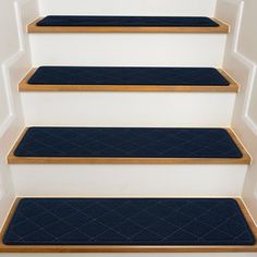 blue carpeted steps leading up to a white wall