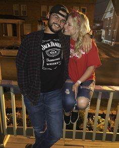 a man standing next to a woman on top of a balcony