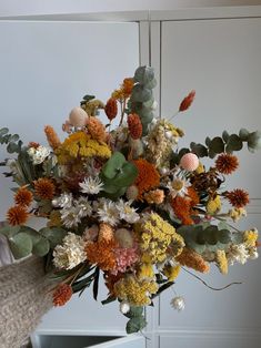 a vase filled with lots of different colored flowers