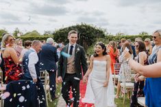 a bride and groom walk down the aisle as confetti is thrown around them