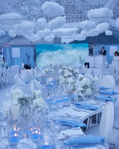 the tables are set with white flowers and blue napkins for an elegant wedding reception