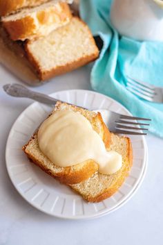 two slices of bread with butter on them sitting on a plate next to a fork