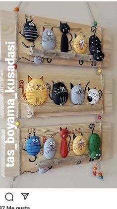 three wooden pegs with cats on them hanging from the wall