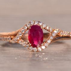 The 184th Avenue: Oval Natural Ruby And Diamond Ring In Rose Gold. The Ring Showcases A Central 0.45-Carat Oval Brilliant-Cut Medium Very Slightly Purplish-Red Natural Ruby, Radiating Elegance And Sophistication. Its Sweeping And Overlapping Split Shank Is Adorned With 0.22 Carats Of Round Brilliant-Cut Natural Diamonds, Delicately Wrapping Around The Center Stone. Crafted In 14 Karat Rose Gold, The Ring Exudes Warmth And Charm. Currently Sized At 6.5, It Can Be Adjusted To Fit Any Finger Size For An Additional Charge Upon Request. Ruby And Diamond Ring, Split Shank, Natural Ruby, Rose Gold Color, Womens Jewelry Rings, Round Brilliant, Pink Yellow, Natural Diamonds, Gold Color