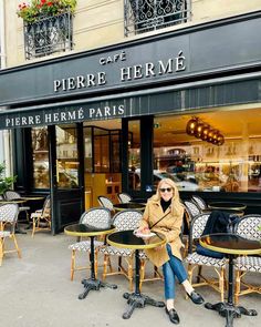 a woman sitting at a table in front of a cafe