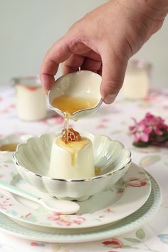 a person pouring sauce into a bowl on top of a plate