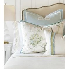 a white bed topped with lots of pillows