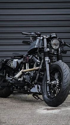 a black motorcycle parked in front of a garage door