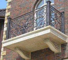 an iron balcony railing on a brick building