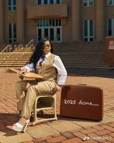 a woman sitting on a chair next to a suitcase with the word done written on it