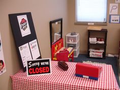 there is a red and white checkered table cloth on the table in this classroom