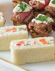 several pieces of food on a plate next to some breads with toppings in them