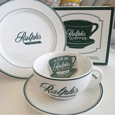 the cups and saucers are sitting on the table next to each other, which is decorated with an old - fashioned logo