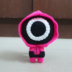 a pink and black stuffed animal with big eyes