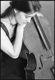 a woman is sitting down with her cello