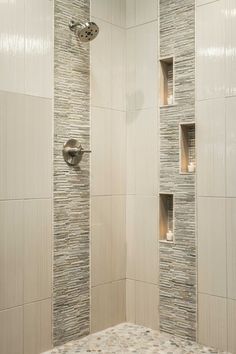 a walk in shower sitting next to a white tiled wall with niches on it