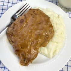 a white plate topped with mashed potatoes and gravy