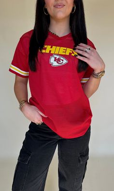 a woman in a red jersey posing for a photo with her hands on her hips