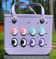 Bring a playful gaze to your favorite Bogg Bag with these charming Peek-A-Boo Emoji Eyes! Each set includes two wide-eyed friends that easily attach to your tote, giving it a personality as unique as your own. Crafted with care, these adorable eyes are designed to add a fun twist to your everyday carryall. Key Features: - Easy Installation: Designed to pop right into the holes of your Bogg Bag, these charms can be added or changed in seconds without any tools required. - Durable Material: Made w Novelty Multicolor Bag For Everyday Use, Playful Rectangular Bags With Removable Pouch, Playful Rectangular Bag With Removable Pouch, Playful Bucket Bag For Everyday Use, Playful Purple Travel Bags, Pink Novelty Bags For Everyday Use, Pink Novelty Bag For Everyday Use, Novelty Rectangular Everyday Bag, Novelty Rectangular Bags For Everyday