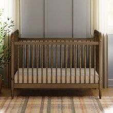 a baby crib in the corner of a room next to a potted plant