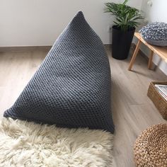 a living room with white walls and wood flooring, rugs on the floor