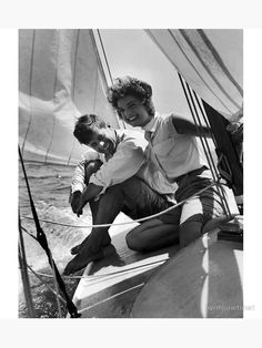 two men sitting on the front of a sailboat