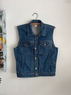 Great vintage Jordache denim vest. 100% cotton. Made in Hong Kong.  Tag size 2 and measures 19 1/2 inches pit to pit and 23 inches long. Measures 17 1/2 inches across the waist when laid flat.  Overall good vintage condition with a light stain on the front. See photos for details. Retro Style Medium Wash Denim Vest, Vintage Dark Wash Vest For Spring, 90s Style Cotton Denim Vest With Pockets, Retro Denim Vest In Medium Wash, Fitted Vintage Denim Vest In Medium Wash, Retro Sleeveless Denim Vest With Pockets, Retro Medium Wash Cotton Denim Vest, 90s Style Sleeveless Denim Vest, Vintage Denim Vest In Medium Wash