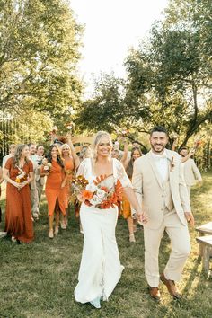 a bride and groom walking down the aisle with their guests holding hands in front of them