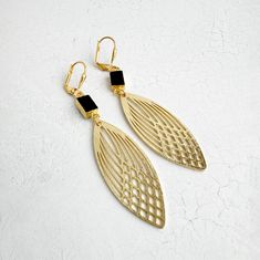 This season, glow for gold in this statement pair with trendy geometric shapes. GEMSTONE: Onyx MATERIAL: Signature brushed gold plating on brass CLOSURE: Gold plated leverback LENGTH: 2.75" long Gold Geometric Earrings For Party, Geometric Gold Earrings For Party, Gold Geometric Jewelry For Party, Gold Statement Earrings, Geometric Earrings, Brushed Brass, Black Onyx, Gold Plating, Gemstone Earrings