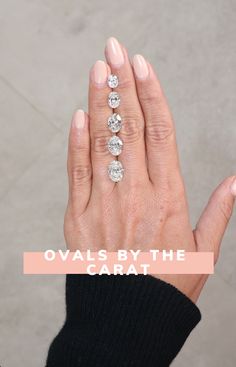 a woman's hand with three diamonds on it and the words oval by the carat