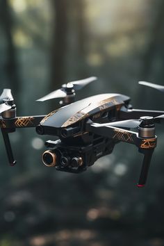 a black and gold remote controlled flying in the air with trees in the back ground