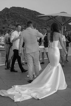 a woman in a wedding dress standing next to a man