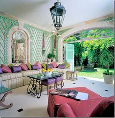 a living room filled with furniture and a large window covered in greenery next to a patio