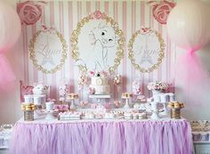 a pink and white dessert table with balloons