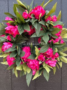 a wreath with pink flowers and green leaves