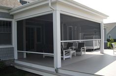 a screened porch with chairs on it