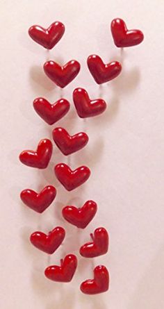 red heart shaped candies are arranged on a white surface