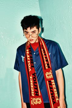 a young man wearing a blue shirt and red scarf with the words keep your eyes open