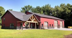 a large red barn sitting on top of a lush green field