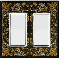 an ornate light switch plate with two white plates on the front and one black and gold wall